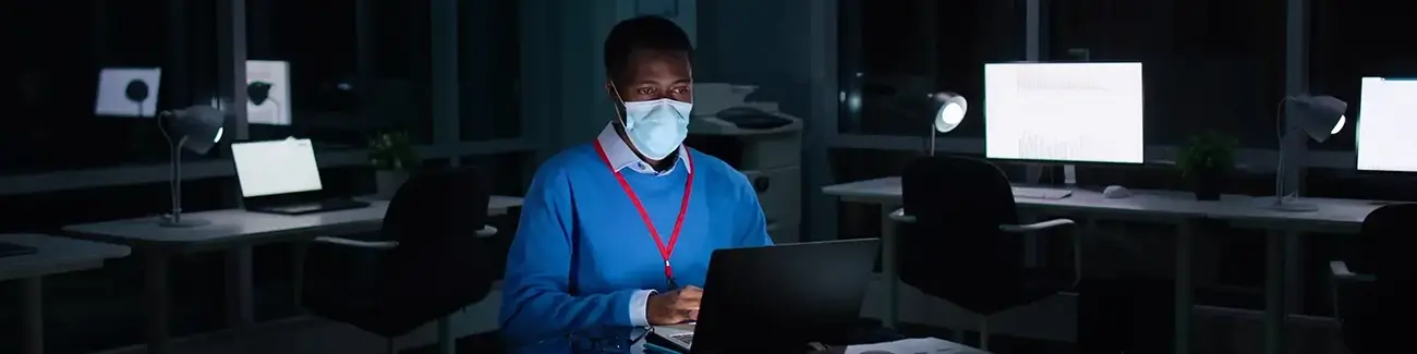 Person with a face mask on in an empty office