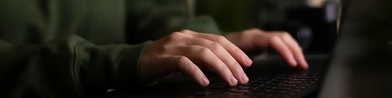 Close-up of person typing on laptop