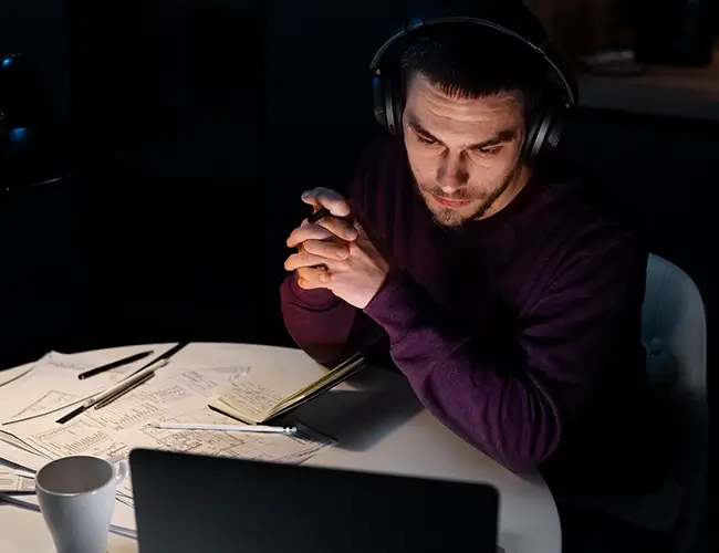 Man looking at laptop while sitting at table